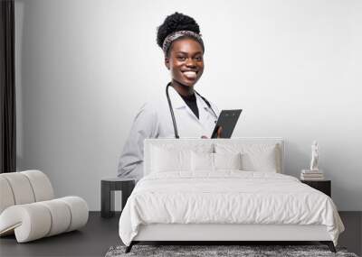 Portrait of happy african medical intern doctor writing on clipboard isolated on white background Wall mural